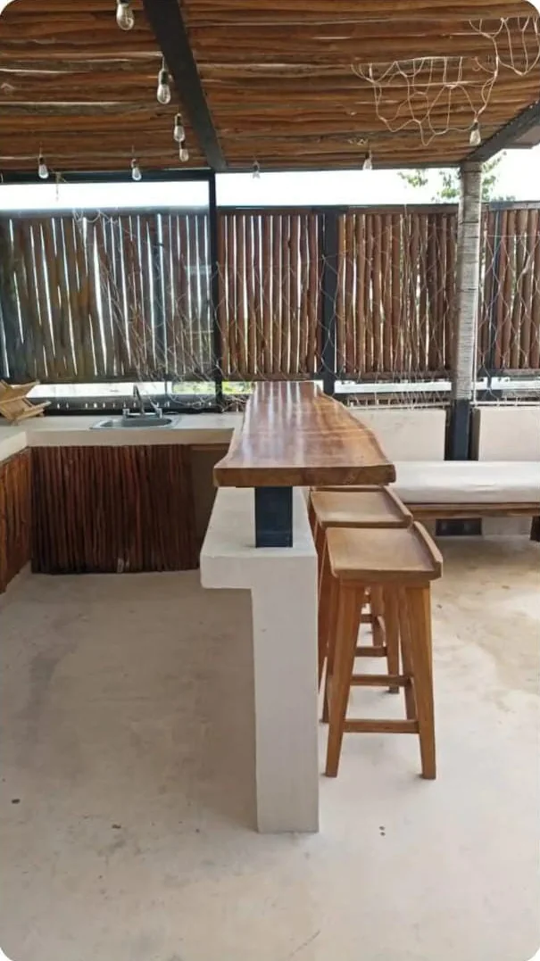 Roof privado con barra de madera y bancos en el penthouse Tuluna, Aldea Zamá